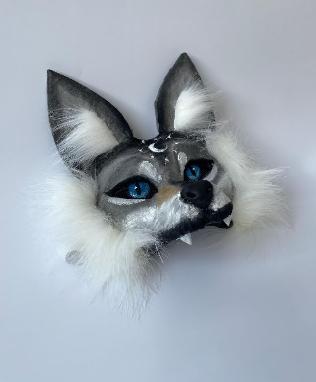 Máscara artesanal de lobo gris con ojos azules y detalles plateados